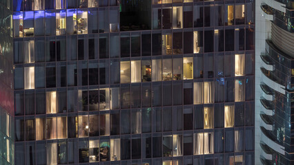 Night view of exterior apartment tower timelapse. High rise skyscraper with blinking lights in...