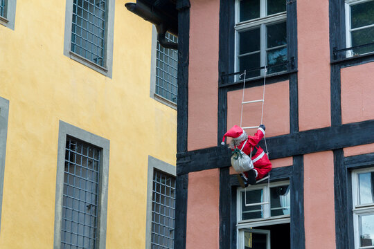 eine Weihnachtsmannpuppe mit einer Leiter an einer Hauswand eines Fachwerkhauses in Bamberg, Bayern