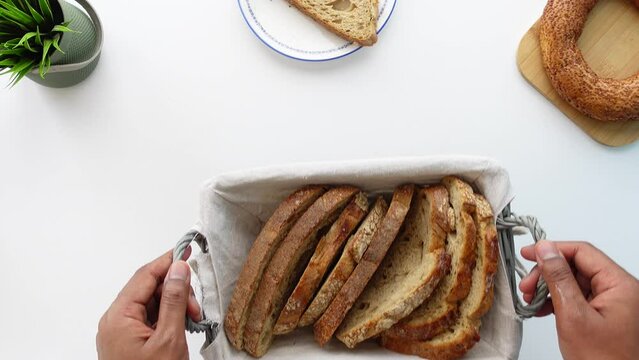 top view of hand pick wheat multigrain bread from a bucket 