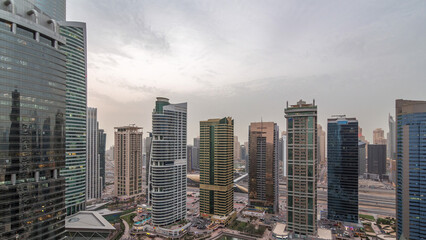 Obraz premium Residential and office buildings in Jumeirah lake towers district day to night timelapse in Dubai