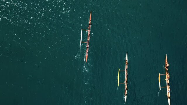 Overhead shot of athletic teams compete in boating on outrigger canoe, traditional Hawaiian boat in Oahu Island, Honolulu, Hawaii. High quality 4k footage