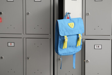 Modern locker with backpack at school, closeup