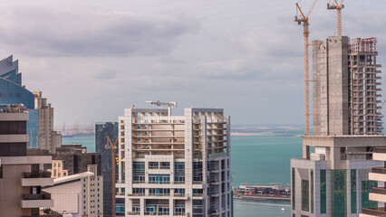 Modern buildings on Dubai Marina and JBR with construction site aerial timelapse in Dubai, United Arab Emirates