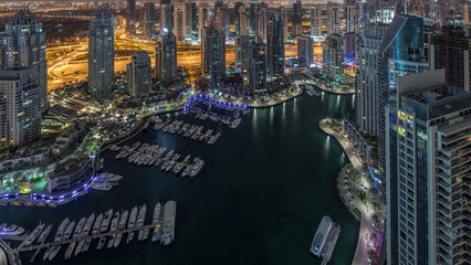 Dubai Marina skyscrapers and jumeirah lake towers view from the top aerial night to day timelapse...