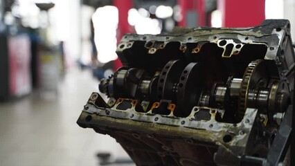 Auto mechanic disassembles engine, removes crankshaft in workshop. Professional service tech inspects cylinder block, bearings. Car repair, maintenance tutorial. Advanced automotive workshop footage.