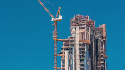 Aerial view of a skyscrapers under construction with huge cranes timelapse in Dubai.