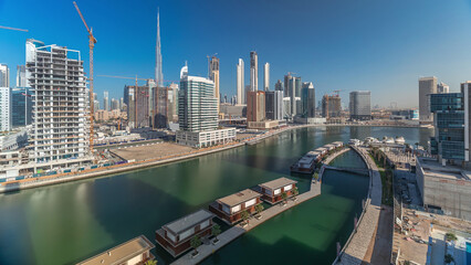 Skyscrapers near canal in Dubai with blue sky aerial timelapse