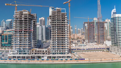 Aerial view of a skyscrapers under construction with huge cranes timelapse in Dubai.