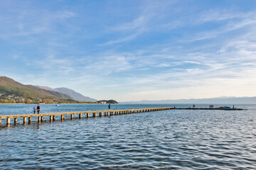 Lake Ohrid, North Macedonia, Spring, Sunset, April 09 2024. Mountain range and peninsula in distance. Ohrid Lake, Macedonia, Europe.The clear mesmerizing waters of lake Ohrid with beautiful view.	