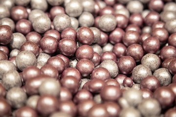 Silver and pink hazelnuts candy background, close-up, cake decorations.