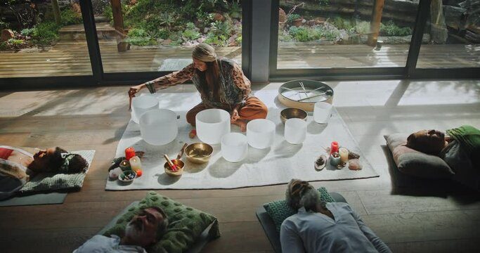 Sound healing, group and yoga for meditation or therapy on floor with drumstick, music or relax with top view. Professional, holistic healer or singing bowl for spiritual mindfulness or mental health