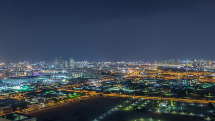 Fototapeta na wymiar The rhythm of the city at night with illuminated road in Dubai near canal aerial timelapse