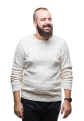 Fototapeta premium Young caucasian hipster man wearing winter sweater over isolated background looking away to side with smile on face, natural expression. Laughing confident.
