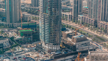 Under construction high-rise building with yellow construction crane in Dubai timelapse