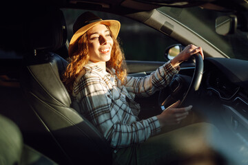 Female driver. Portrait of young woman is driving a car.  Automobile travel. Car sharing.