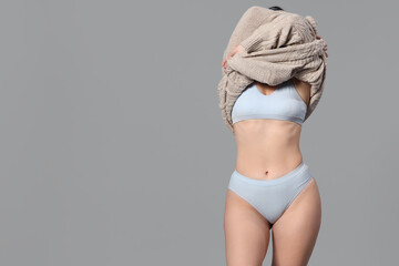 Beautiful young body positive woman with sweatshirt in stylish underwear on grey background