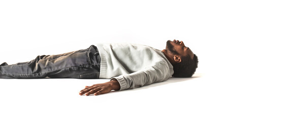Black African American Man Sleeping concept. Eyes closed. White shirt and jean pants. Bearded man. Laying on the isolated white background. Can also represent Fainted, dead, relaxed, relaxation, drunk - obrazy, fototapety, plakaty