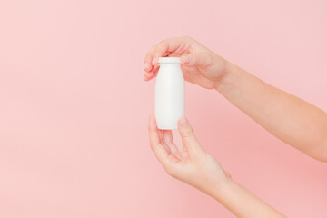 Hand holding bottle of probiotic yogurt for digestive system. Dietary supplements for stomach