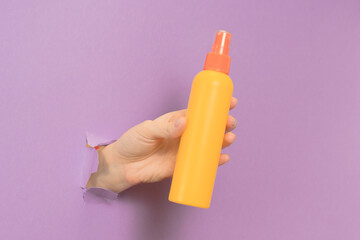 Cosmetic spray container (for skin or hair) in female hand. Cosmetic beauty packaging