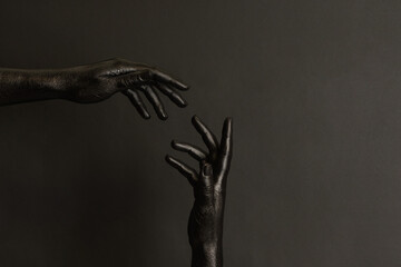 Woman's hands with black paint on her skin on dark background. High Fashion art concept