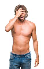 Fototapeta premium Handsome hispanic model man sexy and shirtless over isolated background peeking in shock covering face and eyes with hand, looking through fingers with embarrassed expression.