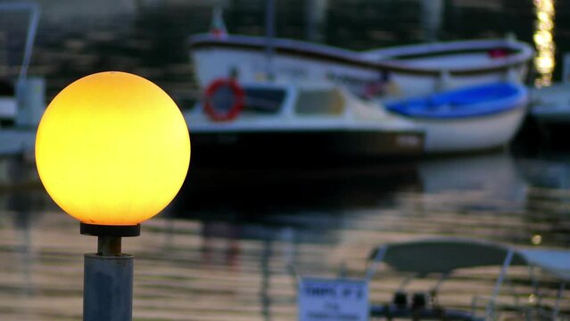 A round flashlight on the background of boats bobbing on the water in the marina