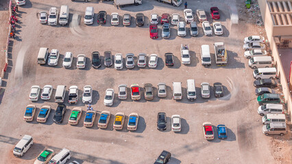 Aerial view full cars at large outdoor parking lots timelapse in Dubai, UAE. - obrazy, fototapety, plakaty
