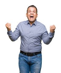 Fototapeta premium Middle age arab business man over isolated background celebrating surprised and amazed for success with arms raised and open eyes. Winner concept.