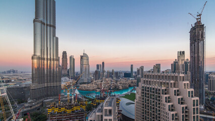 Panoramic skyline view of Dubai downtown after sunset with mall, fountains and skyscrapers aerial...