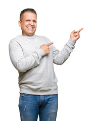 Middle age arab man wearing sport sweatshirt over isolated background amazed and smiling to the camera while presenting with hand and pointing with finger.