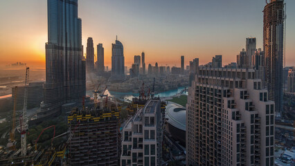 Panoramic skyline view of Dubai downtown during sunrise with mall, fountains and Burj Khalifa...