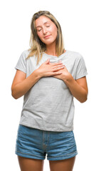 Young beautiful woman over isolated background smiling with hands on chest with closed eyes and grateful gesture on face. Health concept.