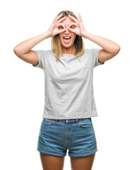 Fototapeta premium Young beautiful woman over isolated background doing ok gesture like binoculars sticking tongue out, eyes looking through fingers. Crazy expression.