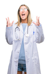 Young beautiful doctor woman headphones over isolated background crazy and mad shouting and yelling with aggressive expression and arms raised. Frustration concept.