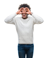 Afro american man over isolated background doing ok gesture like binoculars sticking tongue out, eyes looking through fingers. Crazy expression.