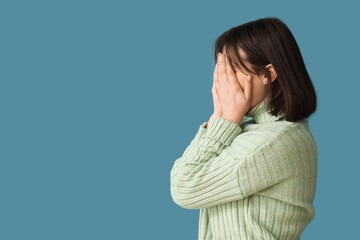 Beautiful young stressed woman on blue background. Stress Awareness Month - obrazy, fototapety, plakaty