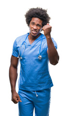 Afro american surgeon doctor man over isolated background angry and mad raising fist frustrated and furious while shouting with anger. Rage and aggressive concept.