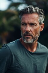 Thoughtful mature man looking away in a natural setting, evoking contemplation and insight