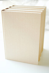 Book with blank white cover standing on white background