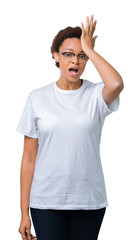 Beautiful young african american woman wearing glasses over isolated background surprised with hand...