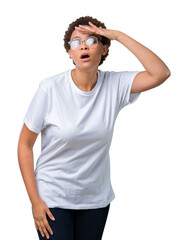 Beautiful young african american woman wearing glasses over isolated background very happy and smiling looking far away with hand over head. Searching concept.