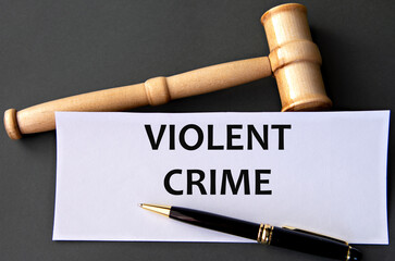 VIOLENT CRIME - words on white paper on dark background with judge's gavel