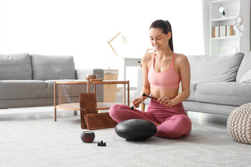 Young woman with Sadhu board and aroma stick playing glucophone at home
