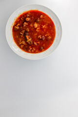 Okra soup with meat, white isolated background.