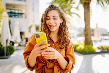 Young woman using smartphone at street. Business, technology, blogging, communication concept.