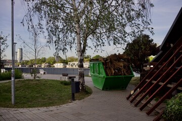 a trash container stands in the park