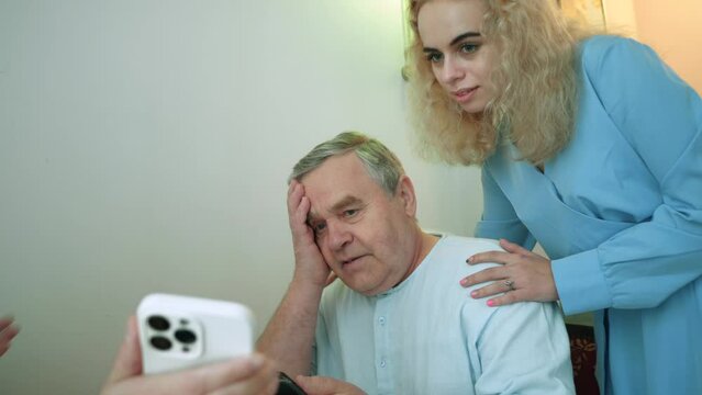 Adult children help an elderly father sort out bills and mobile apps. Supporting the elderly and older people.