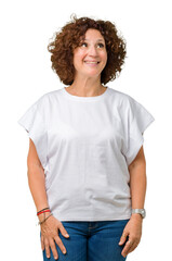 Beautiful middle ager senior woman wearing white t-shirt over isolated background smiling looking...