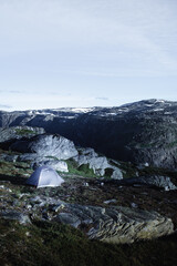 Landscape with tent, blue sky, lake and mountains in Norway, Trolltunga