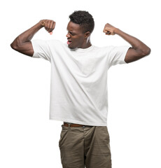 Young african american man wearing white t-shirt showing arms muscles smiling proud. Fitness...